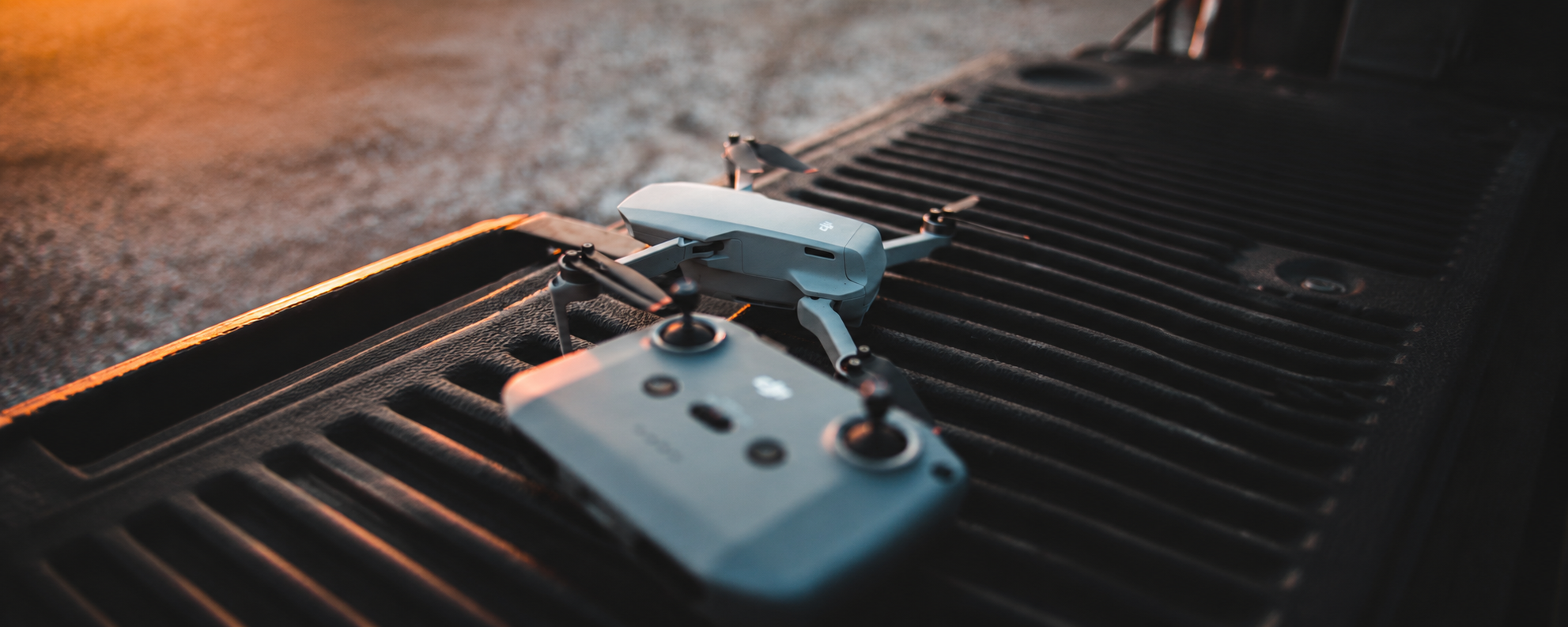 Drone DJI y control remoto sobre camioneta al atardecer en Argentina